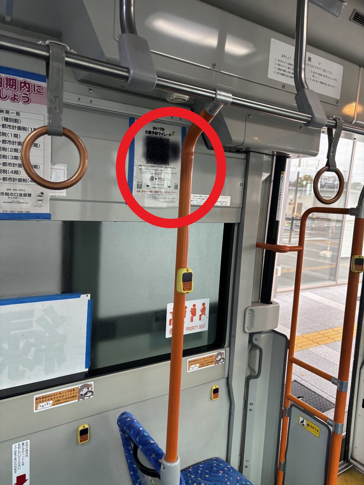 はーもにーばす車両内の写真(入り口横の壁に二次元コードを設置している様子を写しています。)