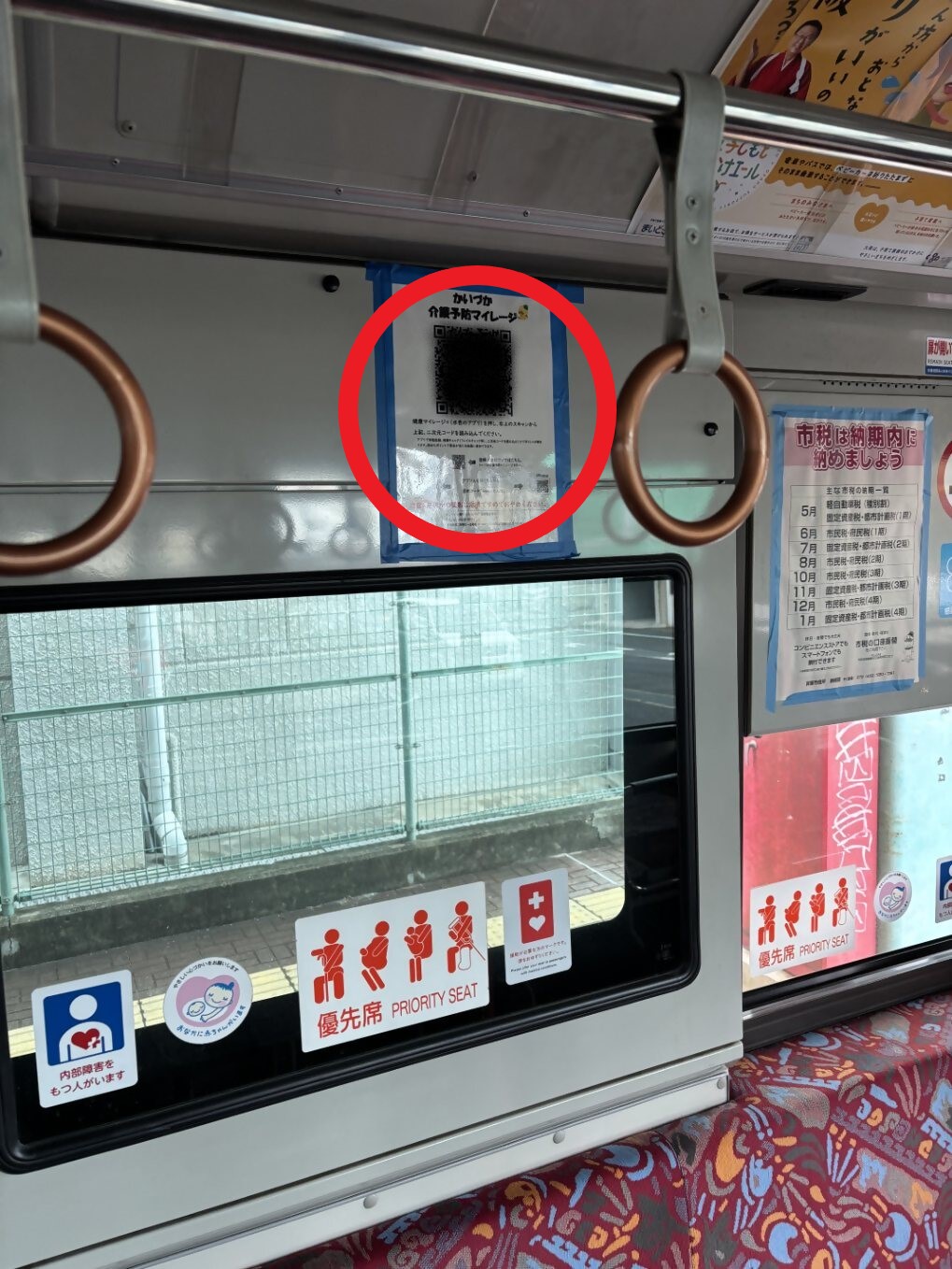 コスモスライナー車両内の写真(壁に二次元コード設置している様子を写しています。)