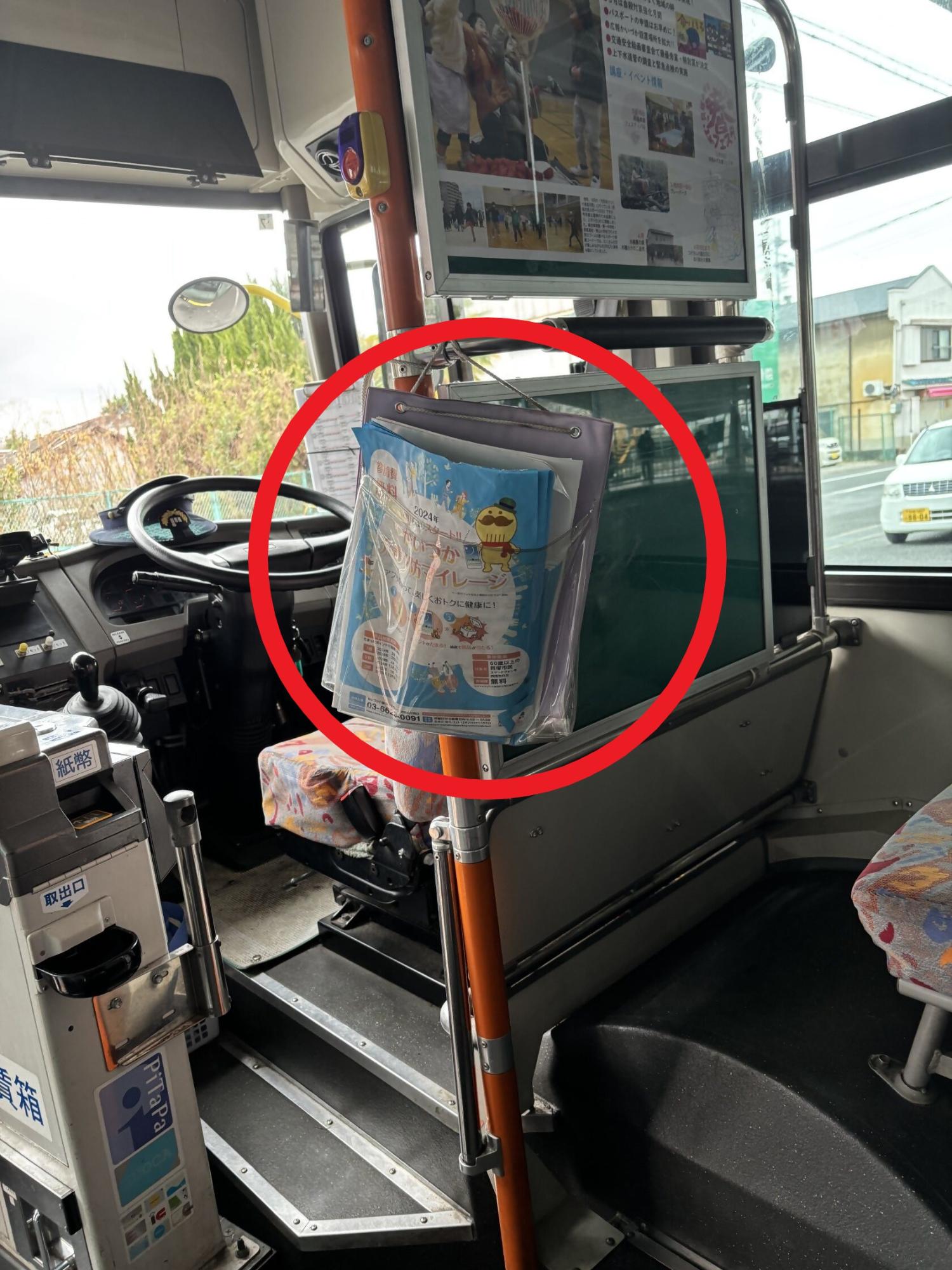 コスモスライナー車両内の写真(運転席横にチラシを設置している様子を写しています。)