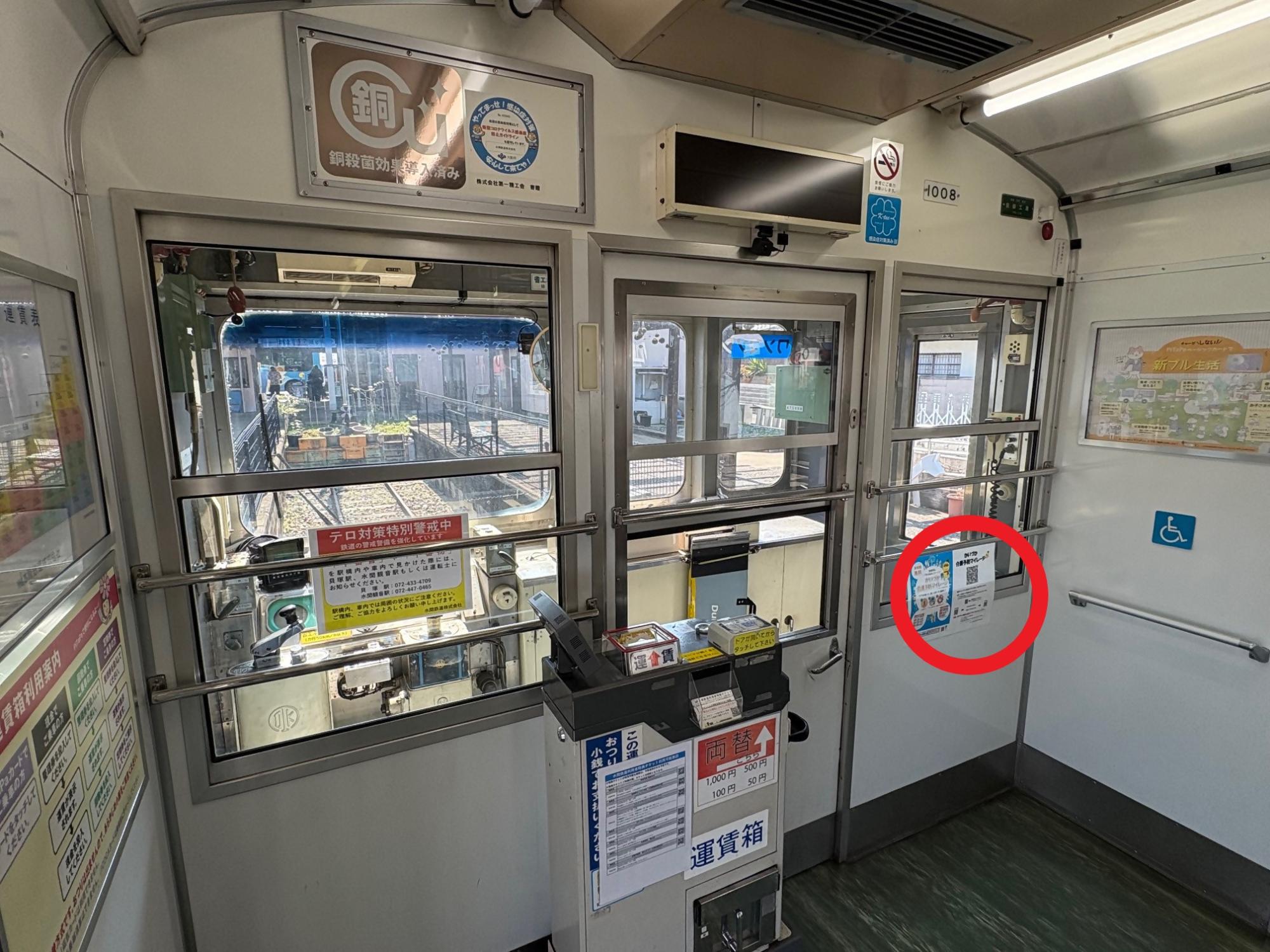 水間鉄道車両内の写真(運転席近くに二次元コードを設置している様子を写しています。)