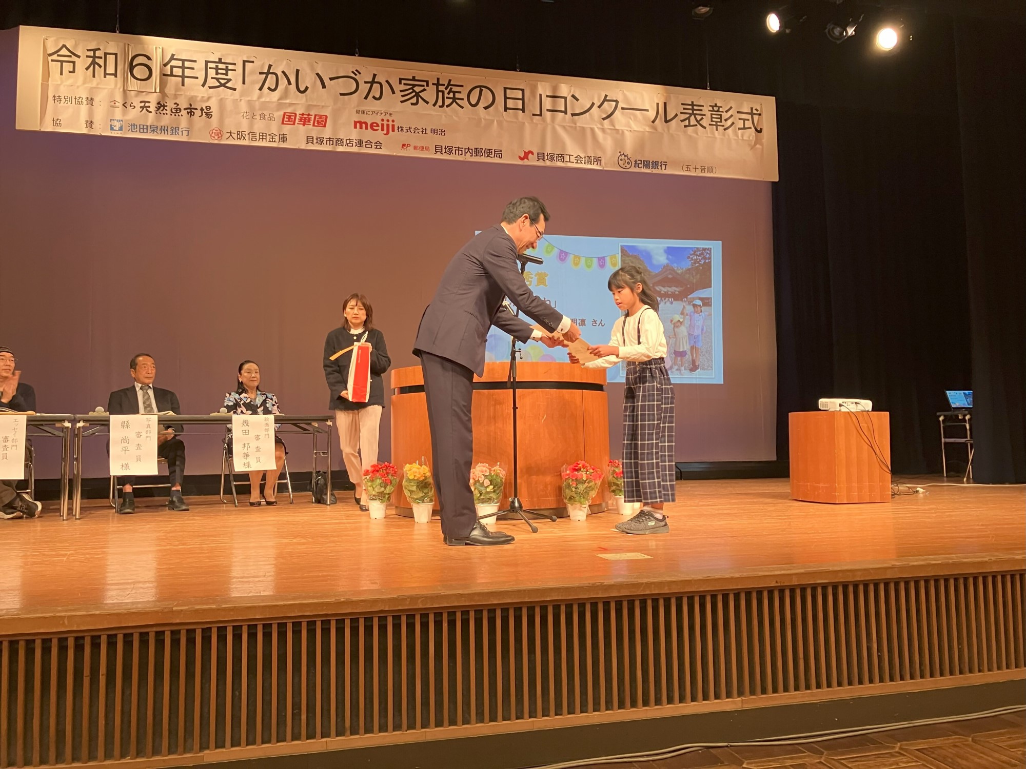 写真部門表彰 最優秀賞受賞者が壇上で賞状を受け取る様子