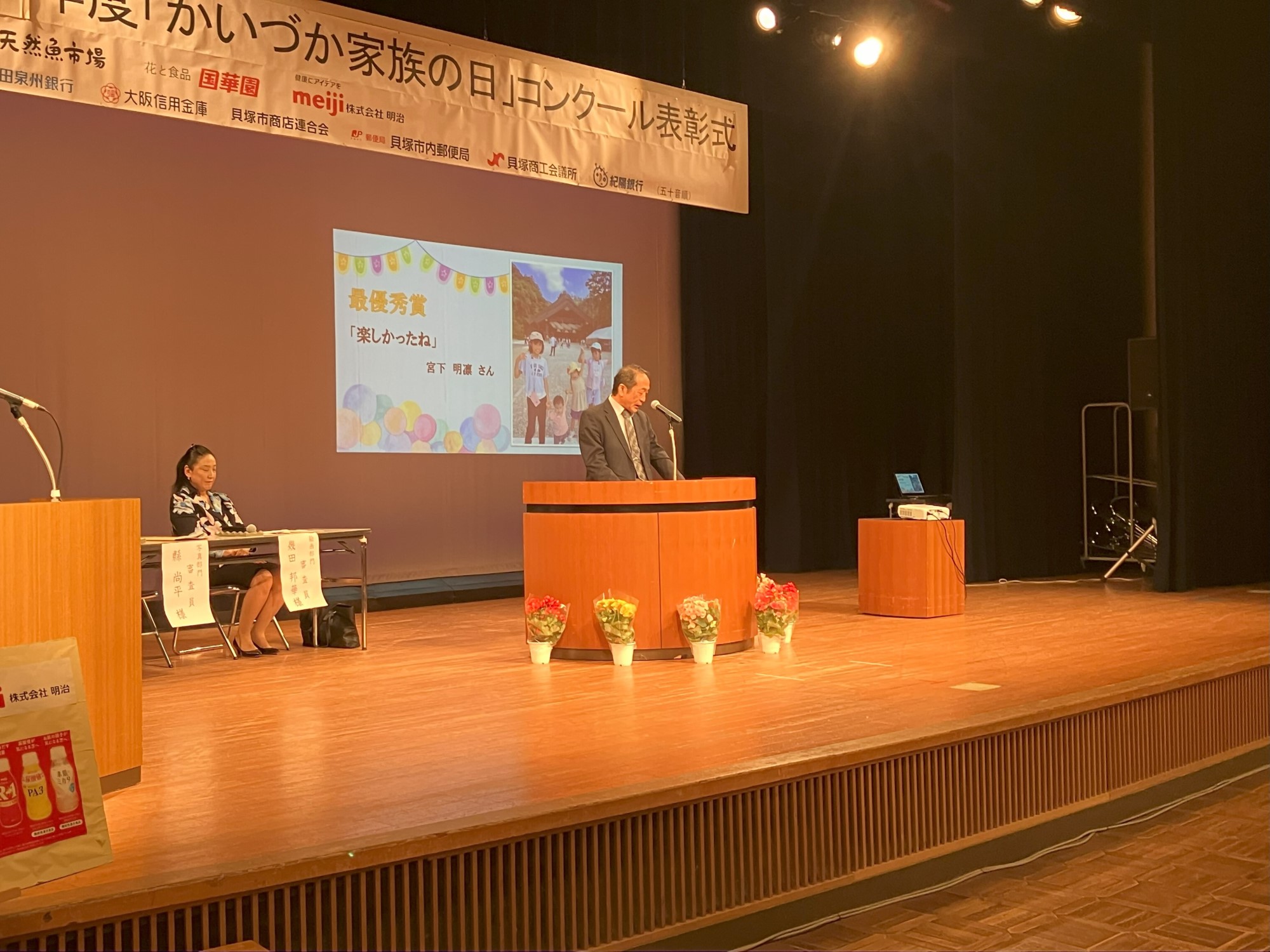 写真部門講評の様子について舞台上のスクリーンに「最優秀賞」のスライドが映し出されている