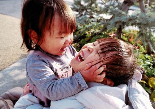 令和5年度かいづか家族の日の写真部門優秀賞作品です 幼い姉妹が抱き合って、妹が姉の頬を両手で包み込んでいる写真です
