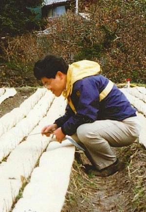 ブナのタネを育てる田中氏の画像