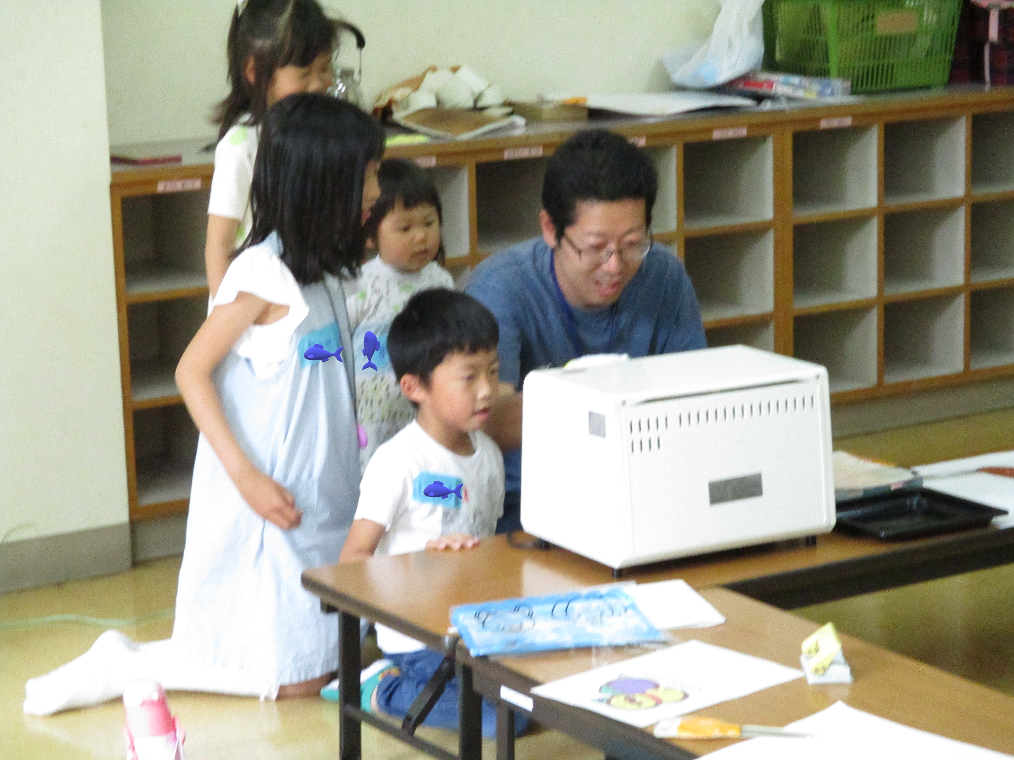プラ板が焼けるのを楽しみに待っている、お父さんと子ども達。