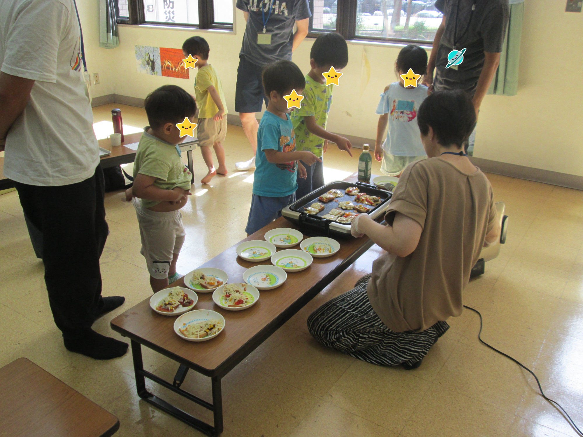 子どもがホットプレートで焼いた食パンピザを取りに来ています。