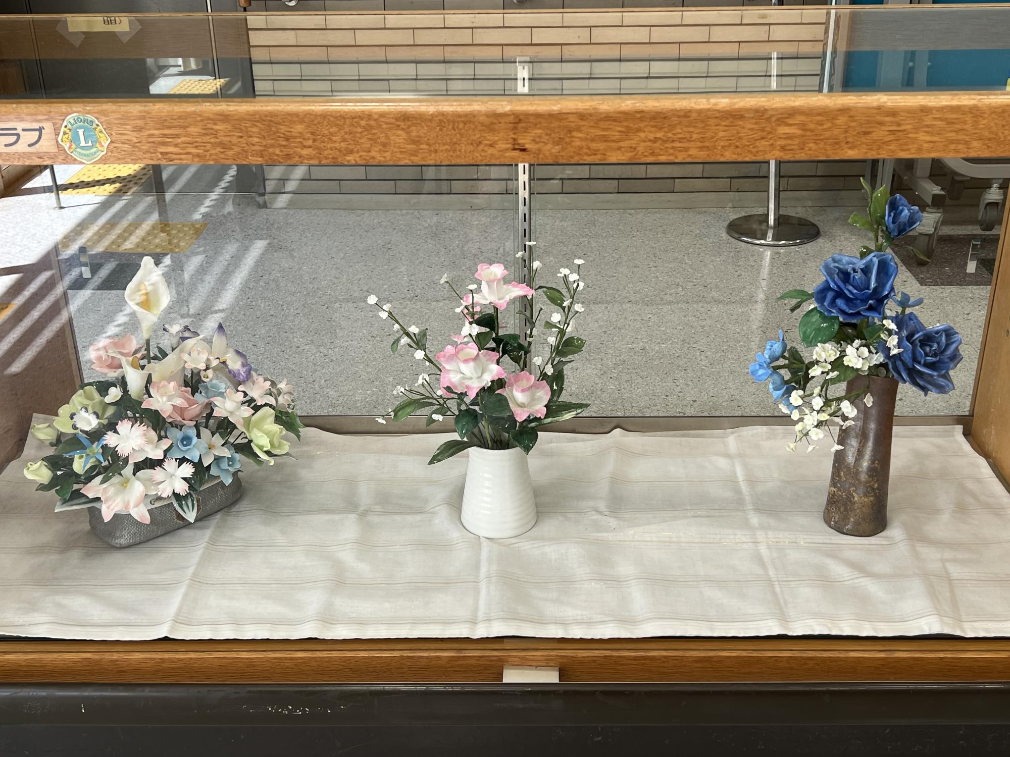 ろうの花クラブのロビー展示の様子です。「ろう」を使って作られた花はまるで実際の花のようです。