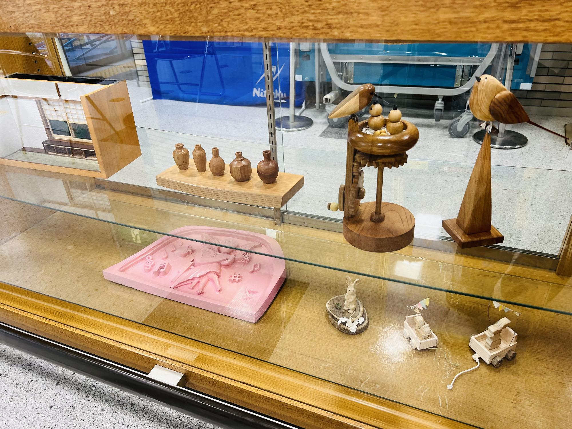 木工クラブの展示作品です。ミニチュアの車や陶芸品、親鳥とひな鳥、和室の一角を再現したものが飾られています。