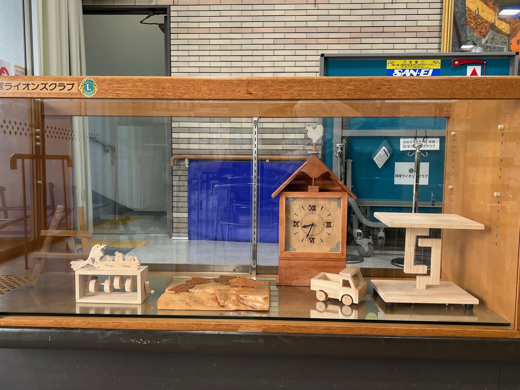 木工クラブのクラブ作品です。木でつくられたミニトラックや、わに、置き時計、親鳥がヒナ達に餌をあげるからくりおもちゃなどが展示されています。