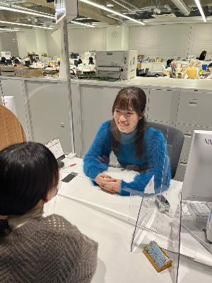 職員が窓口カウンターに座り、市民の対応をする様子です。