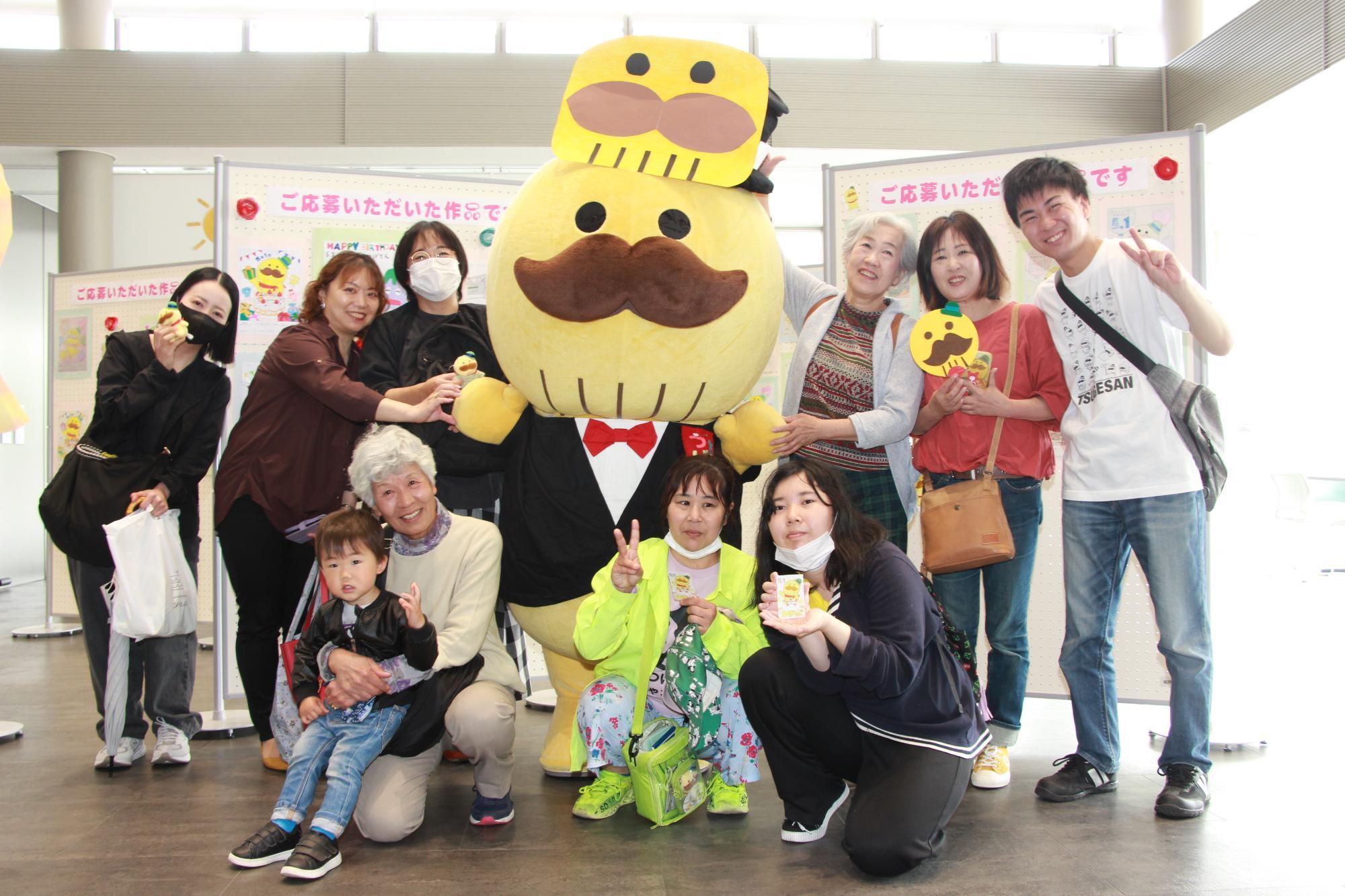 展示作品の前でつげさんと参加者が記念撮影している様子です