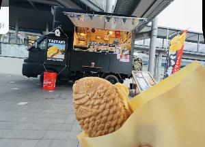 たい焼き屋さんのキッチンカー。黒い車体で売っている。