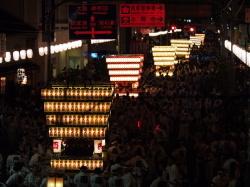 太鼓台祭り夜の練り合いの様子 提灯で装飾した7基の太鼓台が並んで一斉に担ぎ合いを行っている。