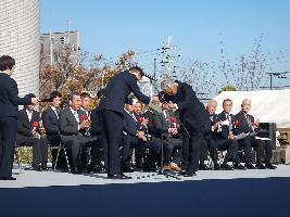 農業祭の式典において、品評会の受賞者が授与者から表彰状を受け取っている写真