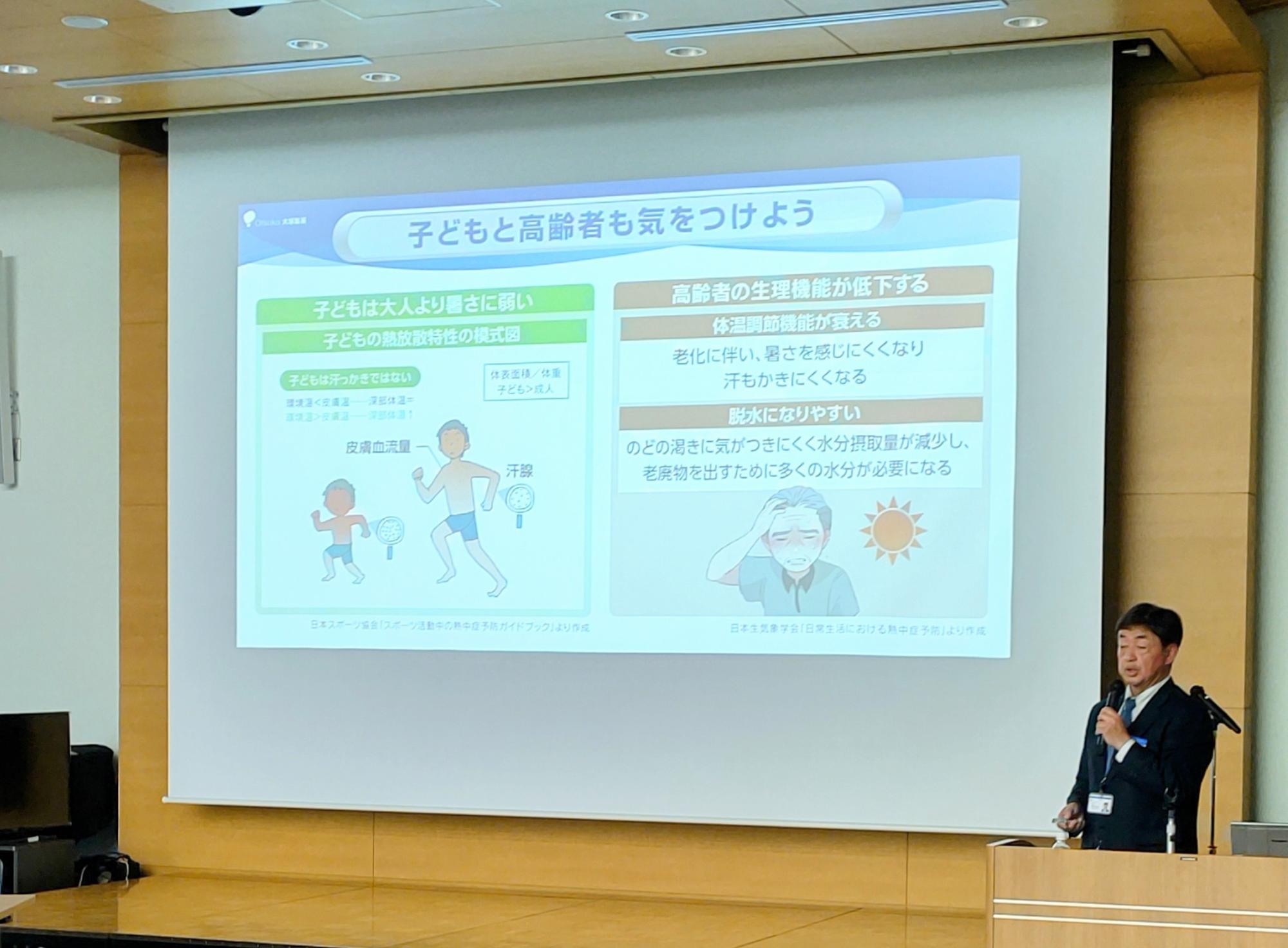 大塚製薬株式会社熱中症対策セミナー講師が講演する様子（スクリーンに「子どもと高齢者も気をつけよう」のスライドが映し出されている）