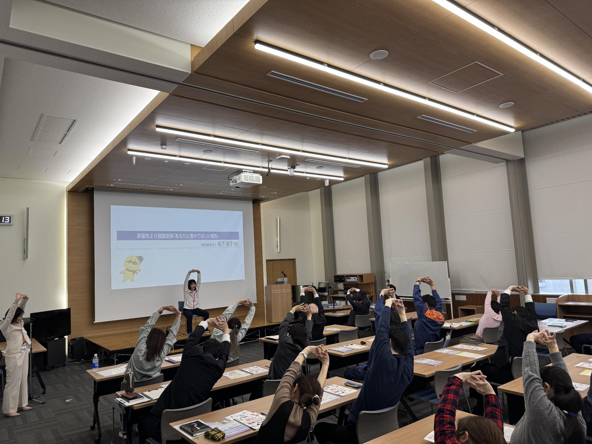 働く女性の健康応援セミナーで健康運動指導士の松下先生による一人ひとりが健康づくりに取り組むためにできる運動について実際に参加者と一緒に行っている様子