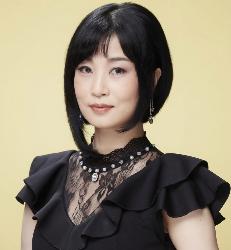 黒いドレスを着用し、柔和な表情で微笑む歌手れいかさんの写真