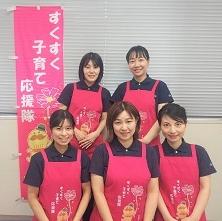 ピンクのエプロンをつけた応援隊5人の画像。