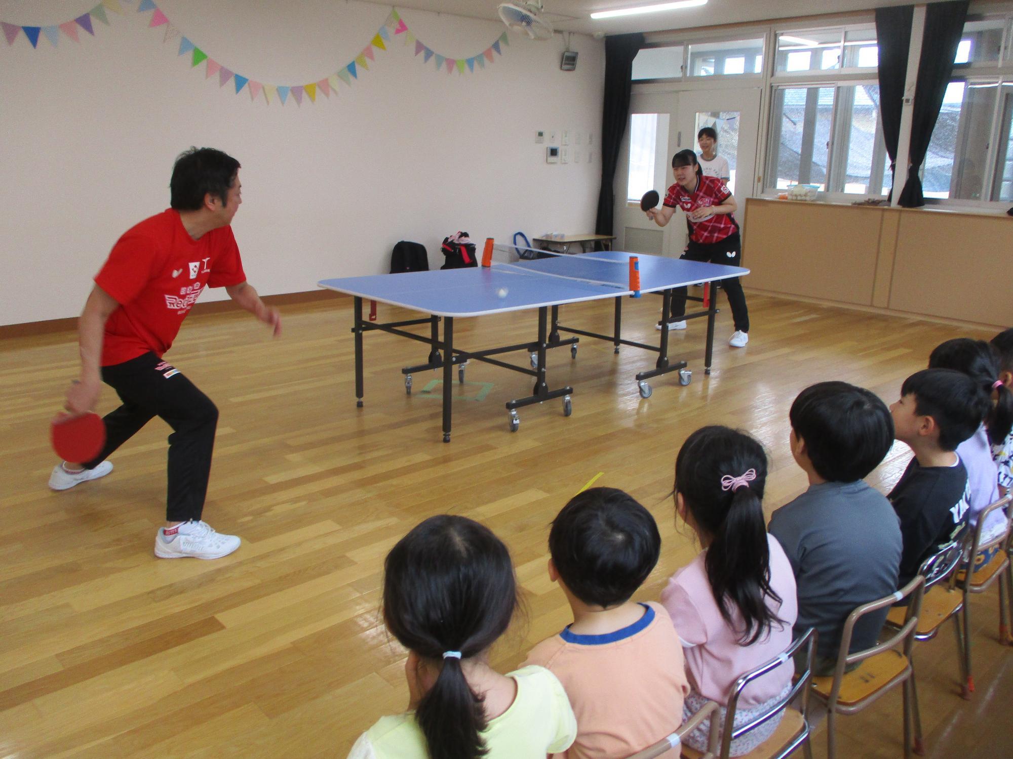 日本生命レッドエルフの選手とコーチが子どもたちにラリーを披露している様子