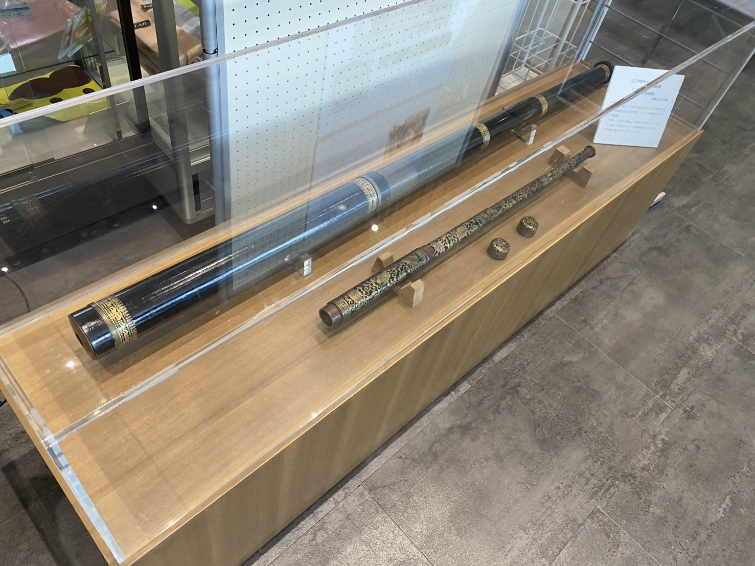 岩橋善兵衛の望遠鏡が2本展示されているガラスケースを撮影した写真