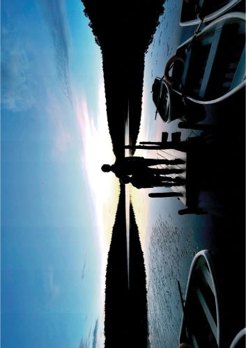 朝焼けの中、八ヶ岳の白駒池を父親と男の子が眺めている姿を後ろから撮った写真です。
