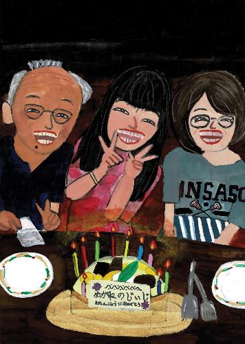 祖父と女性2人が祖父の誕生日ケーキを囲んで笑顔でポーズを取っているようす。