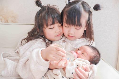 写真部門の優秀賞作品です。姉と一緒に生まれた弟にミルクをあげている様子です。