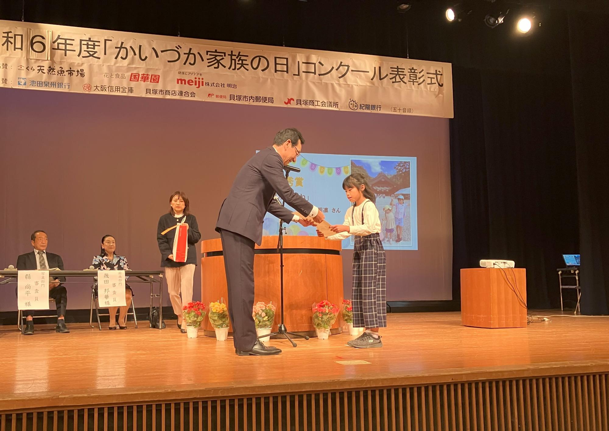 教育長が写真部門の最優秀賞受賞者に表彰状を授与している様子です。