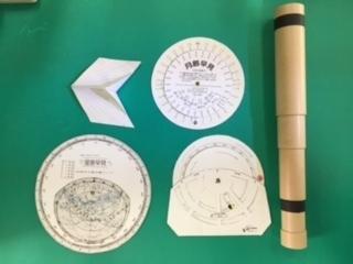 観測器具の写真、星座早見盤や望遠鏡があります。