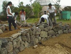 市民ボランティアの方がトンボの池の護岸の石を積んでいる様子（1997年）