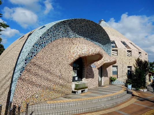 自然遊学館の入り口側の外観。貝塚市蕎原で発掘されたアンモナイト化石をもとにデザインされています。