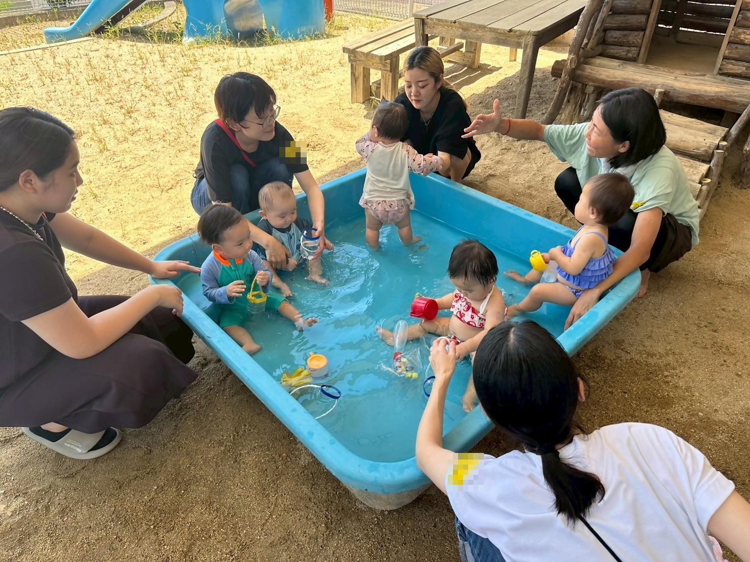 赤ちゃんが水遊びをしている様子