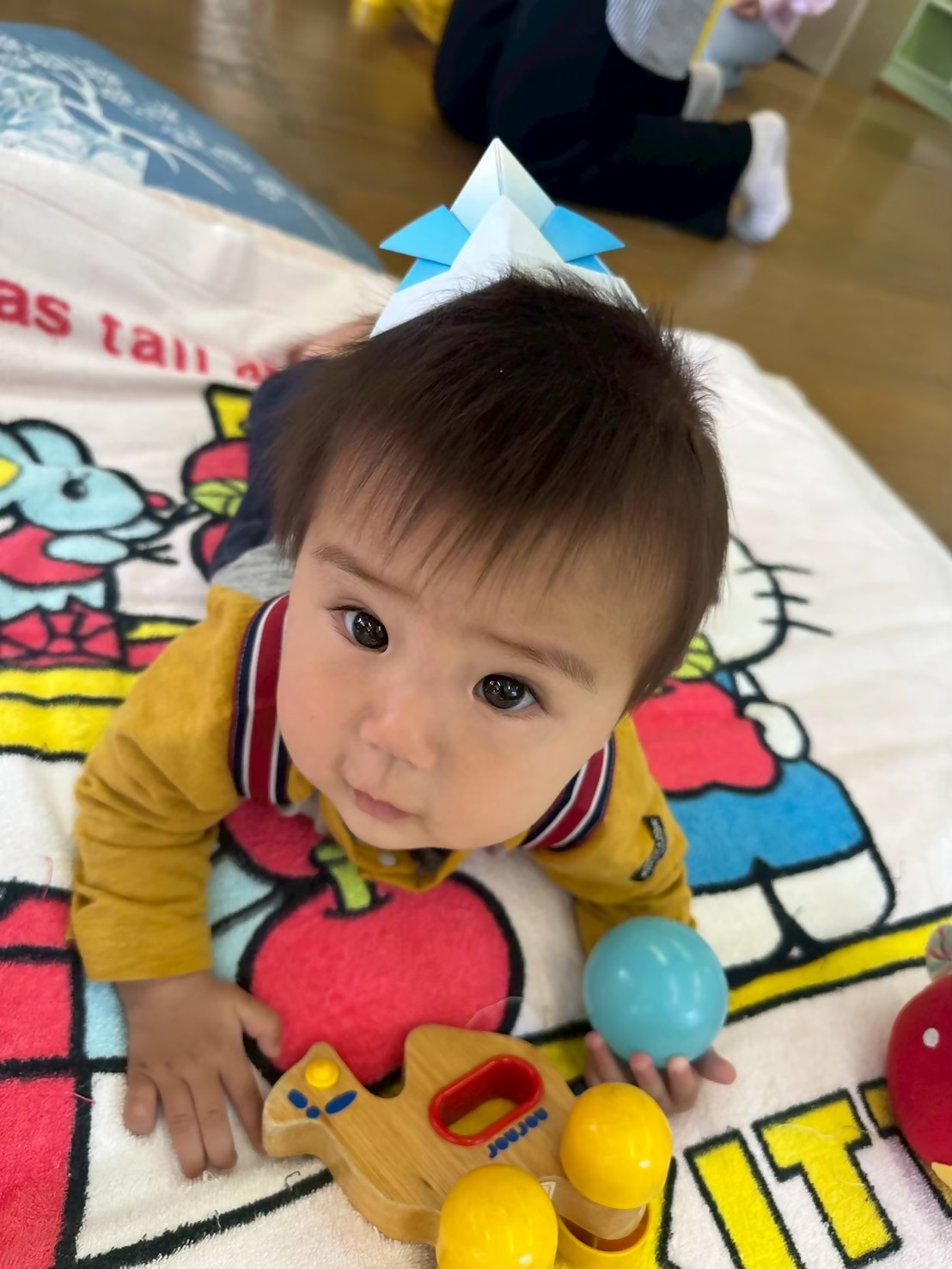 こどもの日の講座で折り紙で作ったカブトを赤ちゃんがかぶっています