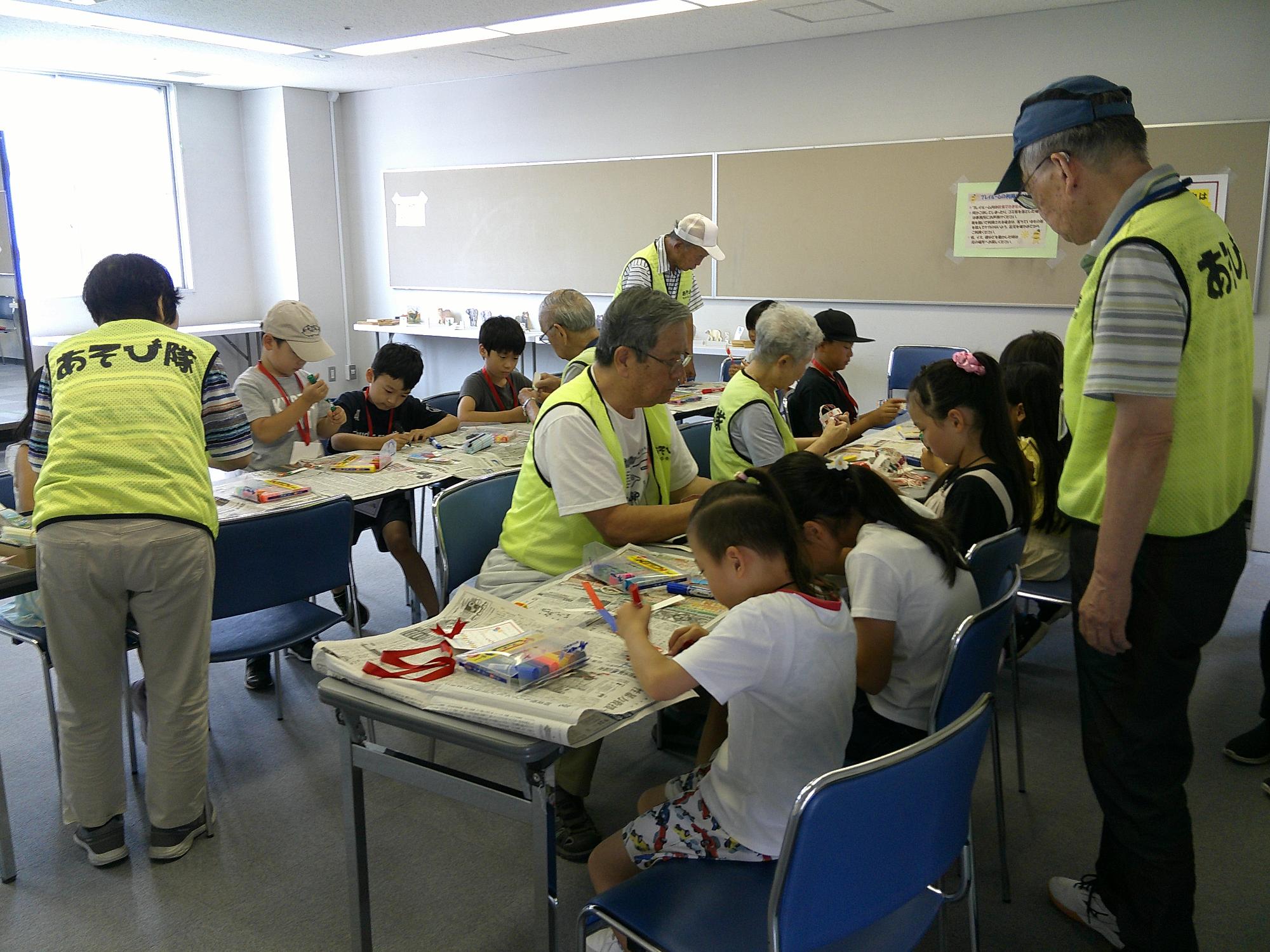 子ども達がブンブンゴマを制作している様子です