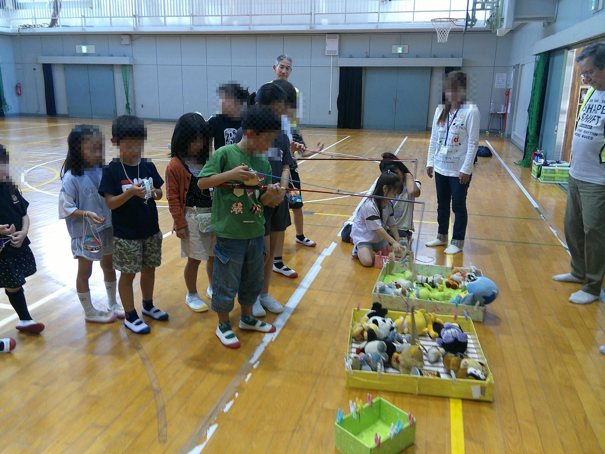子ども達がユーフォ―キャッチャーで遊んでいる様子です