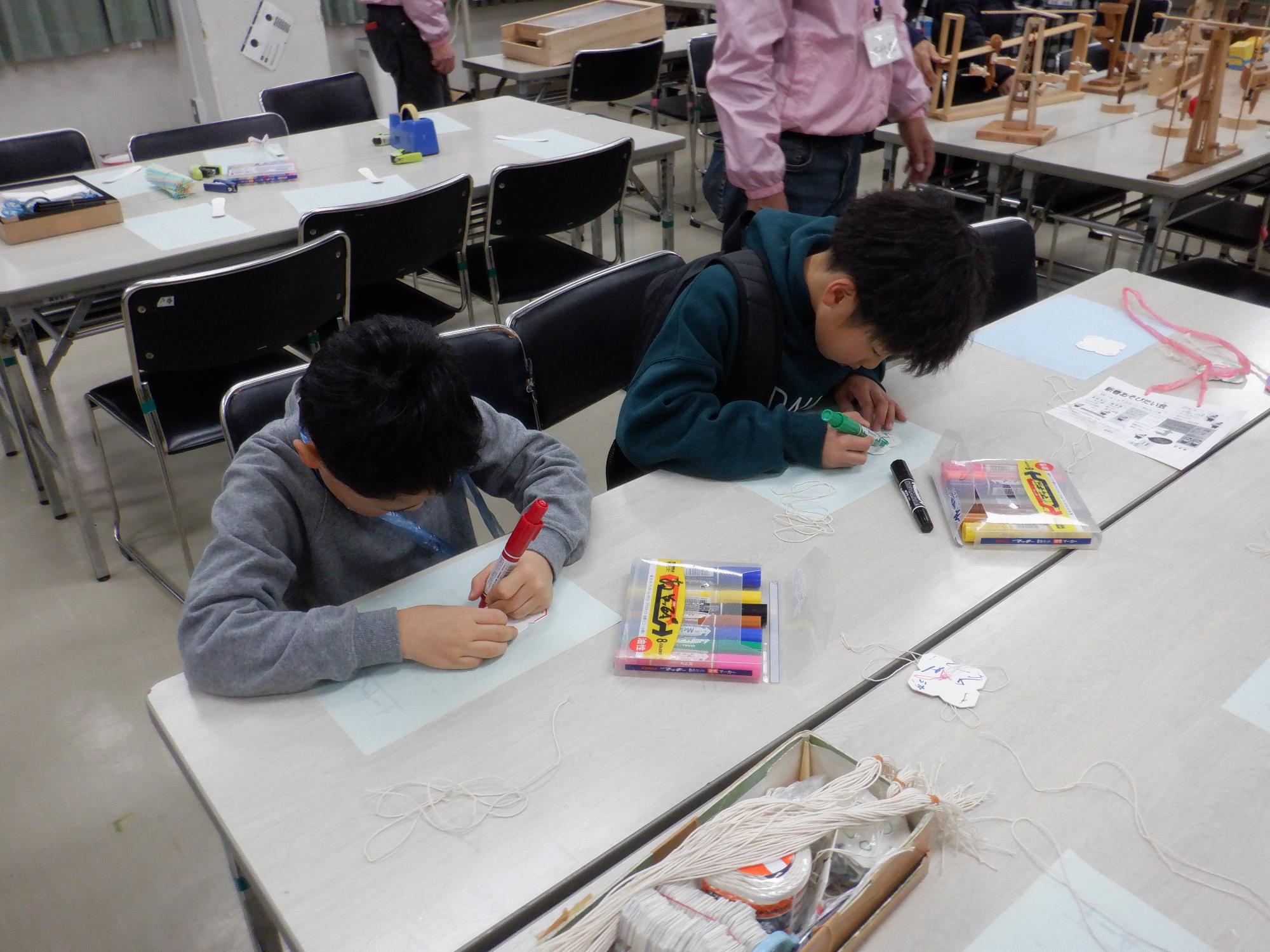 子どもたちが作品に色をぬっている様子