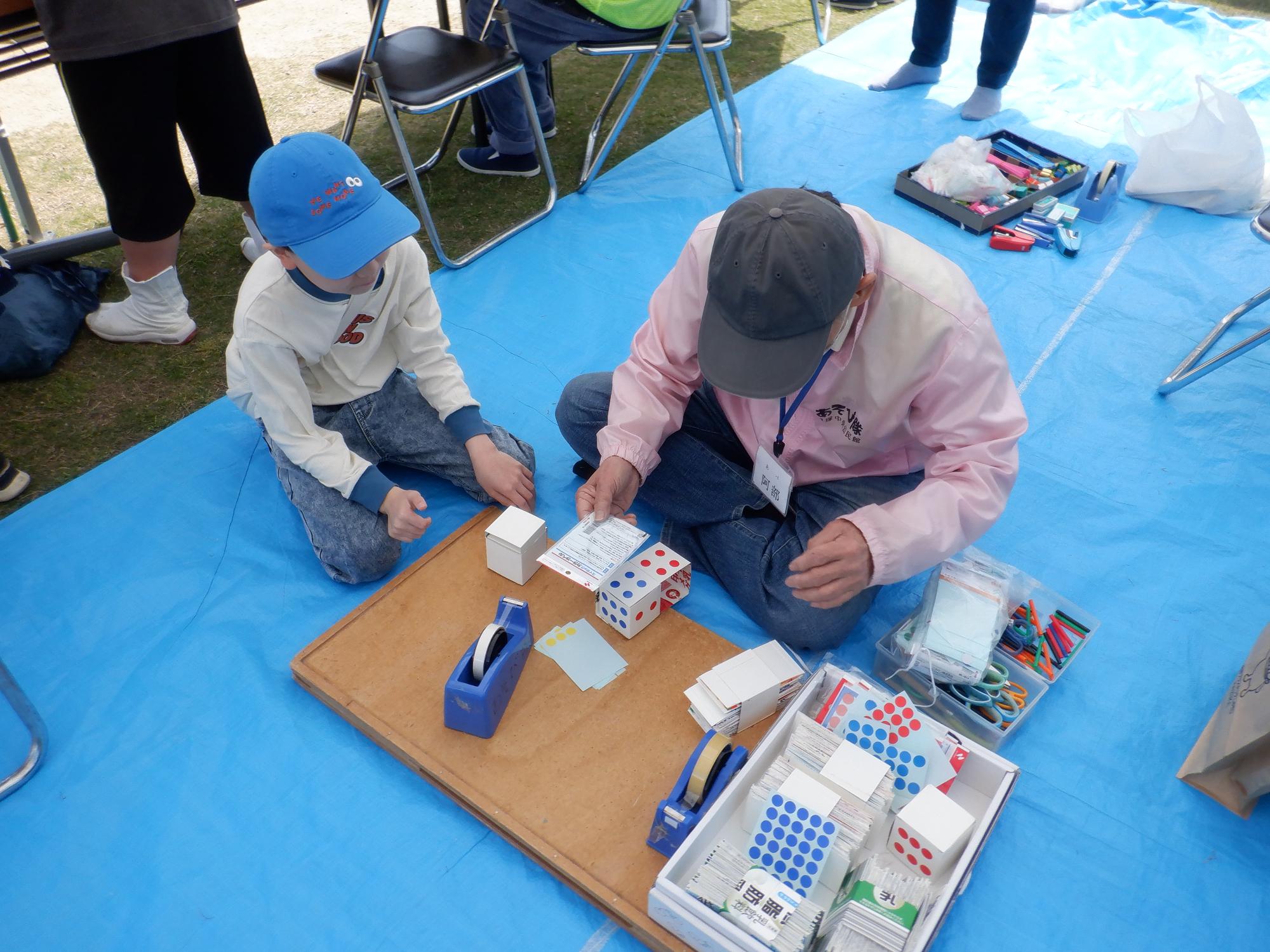 隊員におもちゃの作り方を教えてもらっている様子