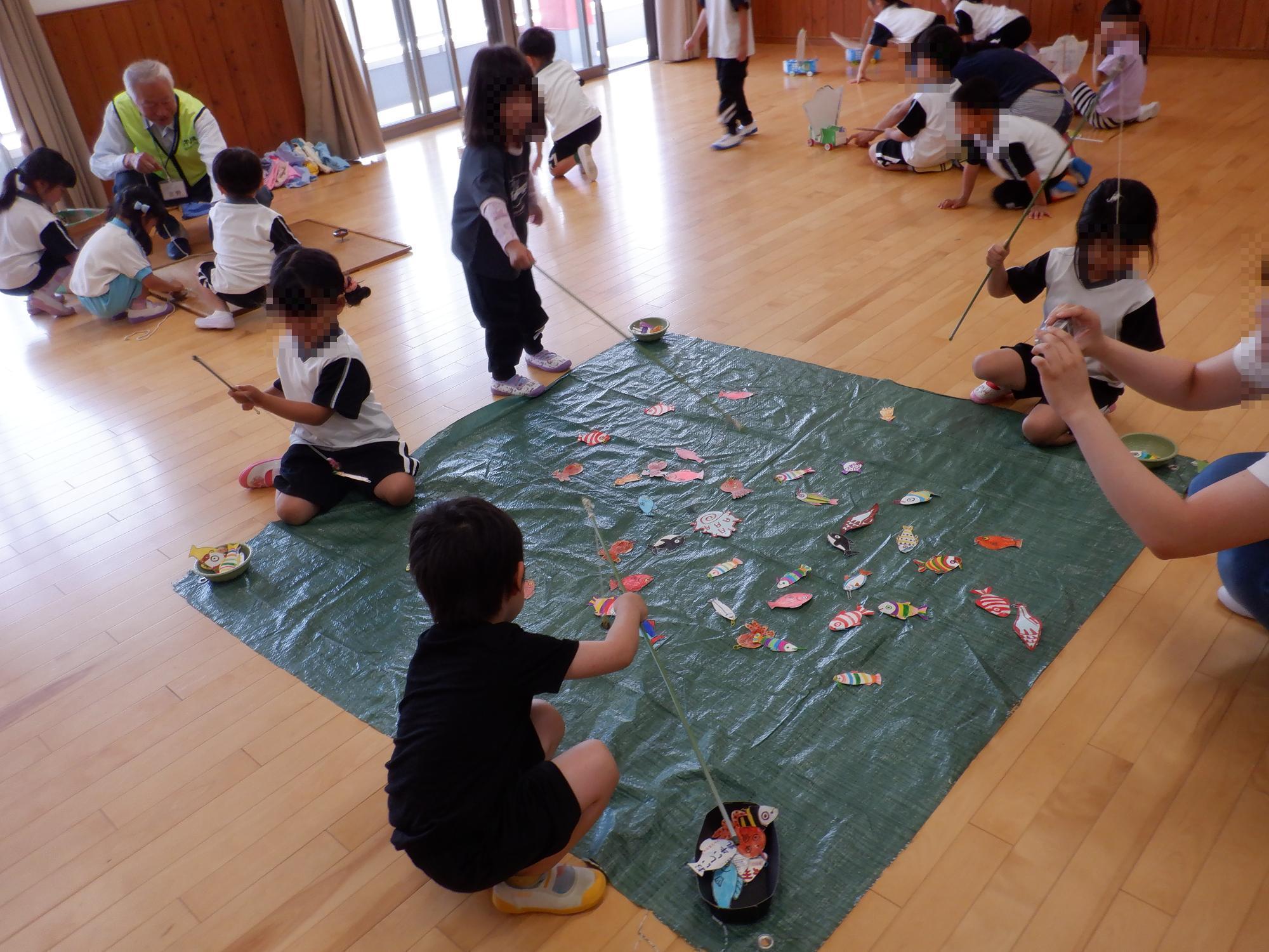 子ども達が魚釣りで遊んでいる様子