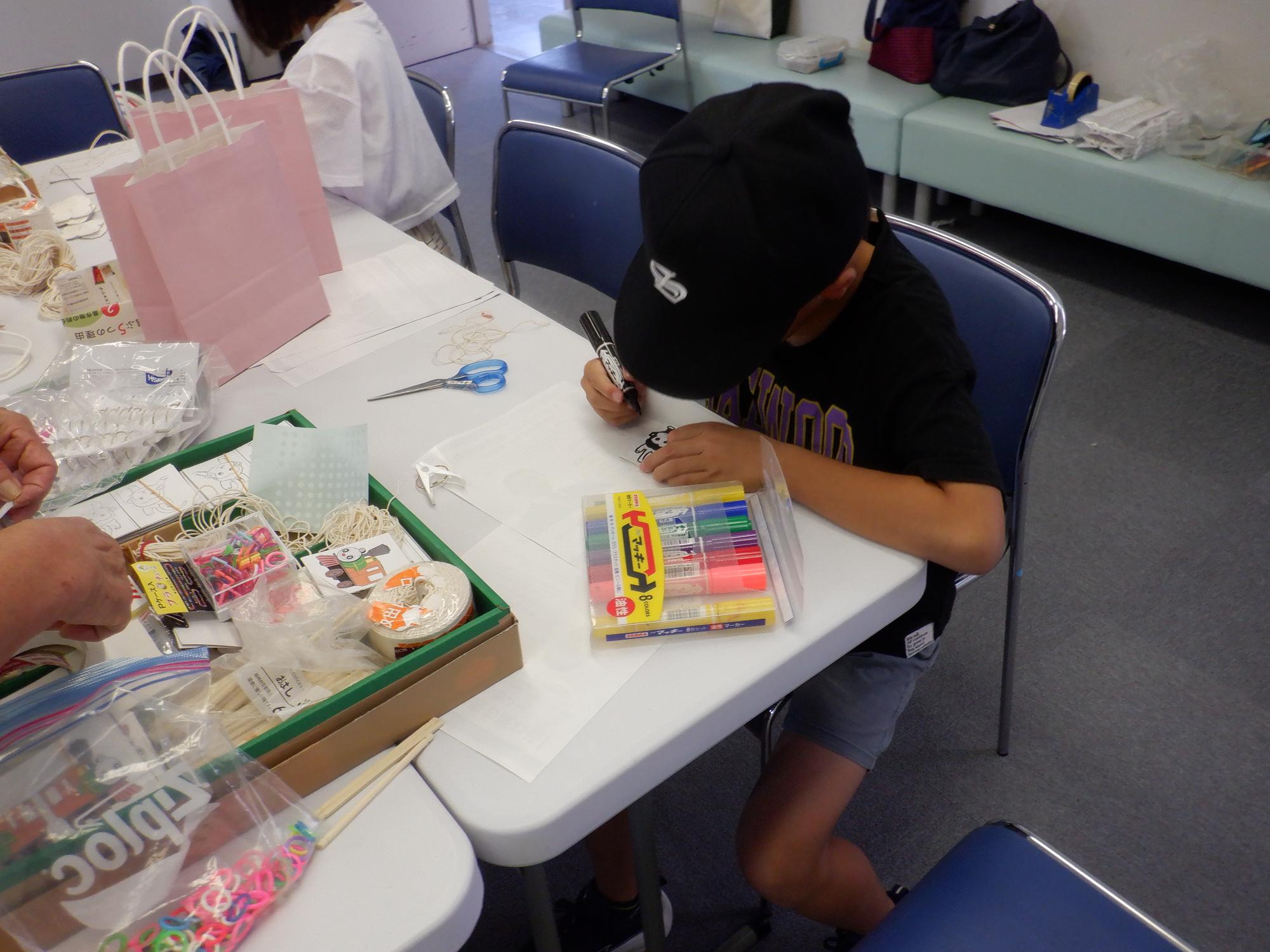 子どもがブンブンゴマを工作している様子です