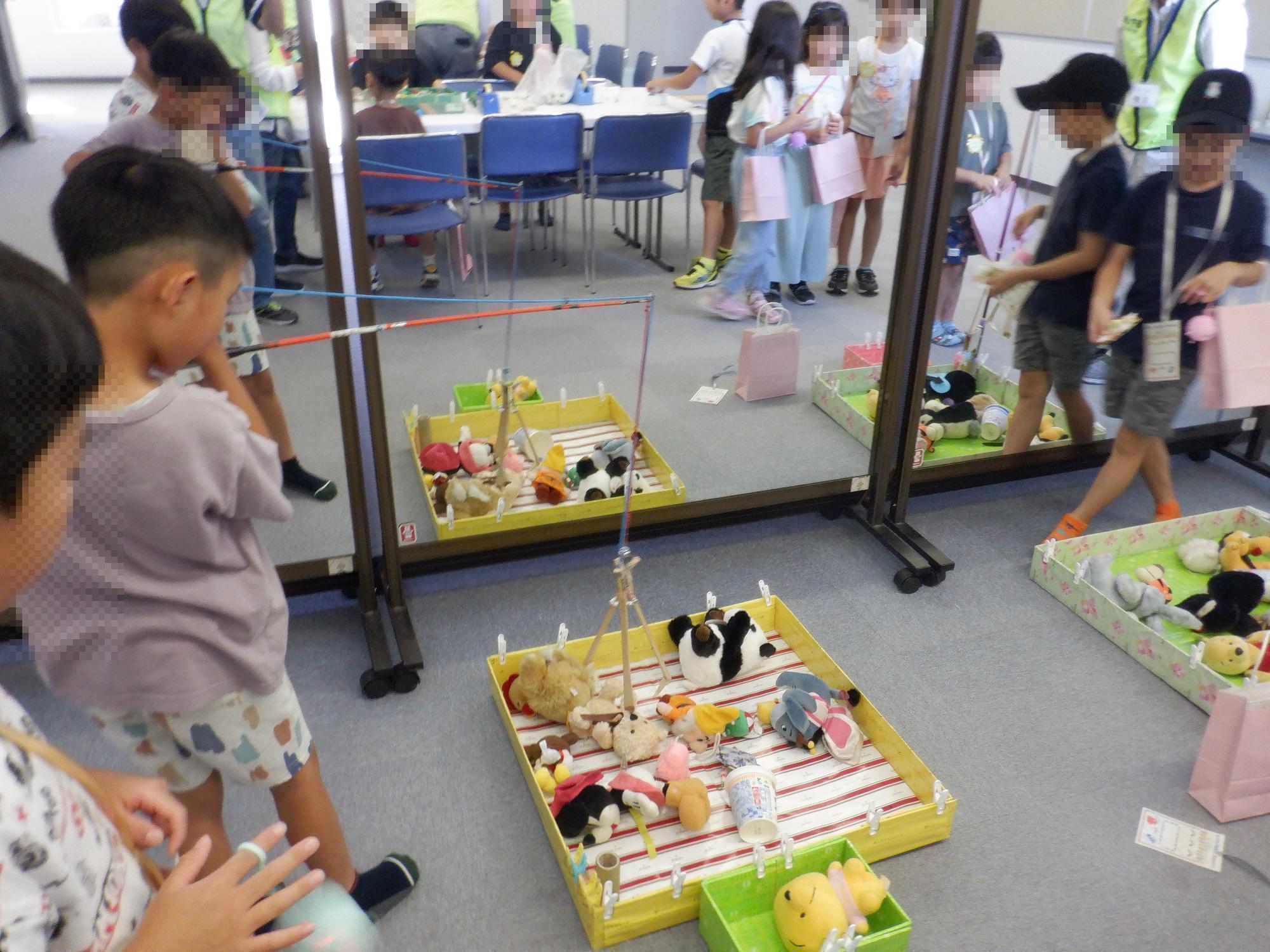 子ども達がユーフォ―キャッチャーで遊んでいる様子です