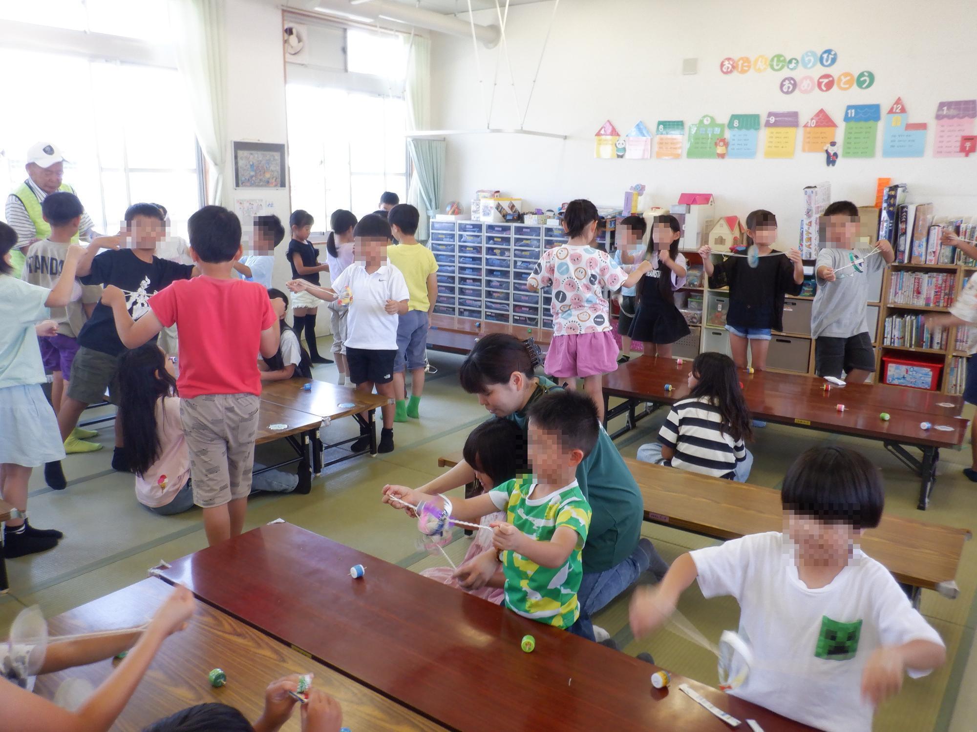 子ども達がブンブンゴマを回している様子です