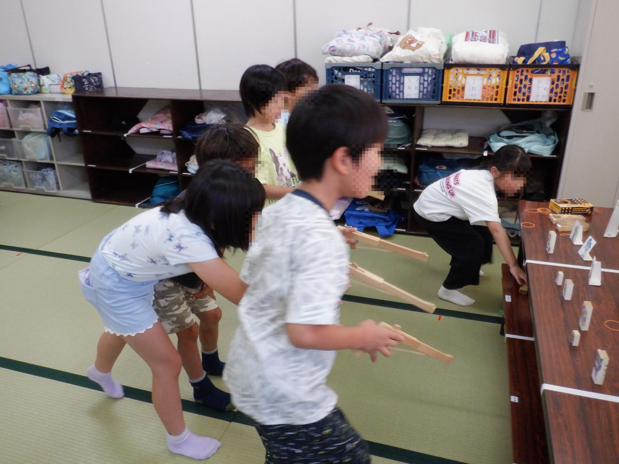 子ども達が鉄砲の的当てで遊んでいる様子です