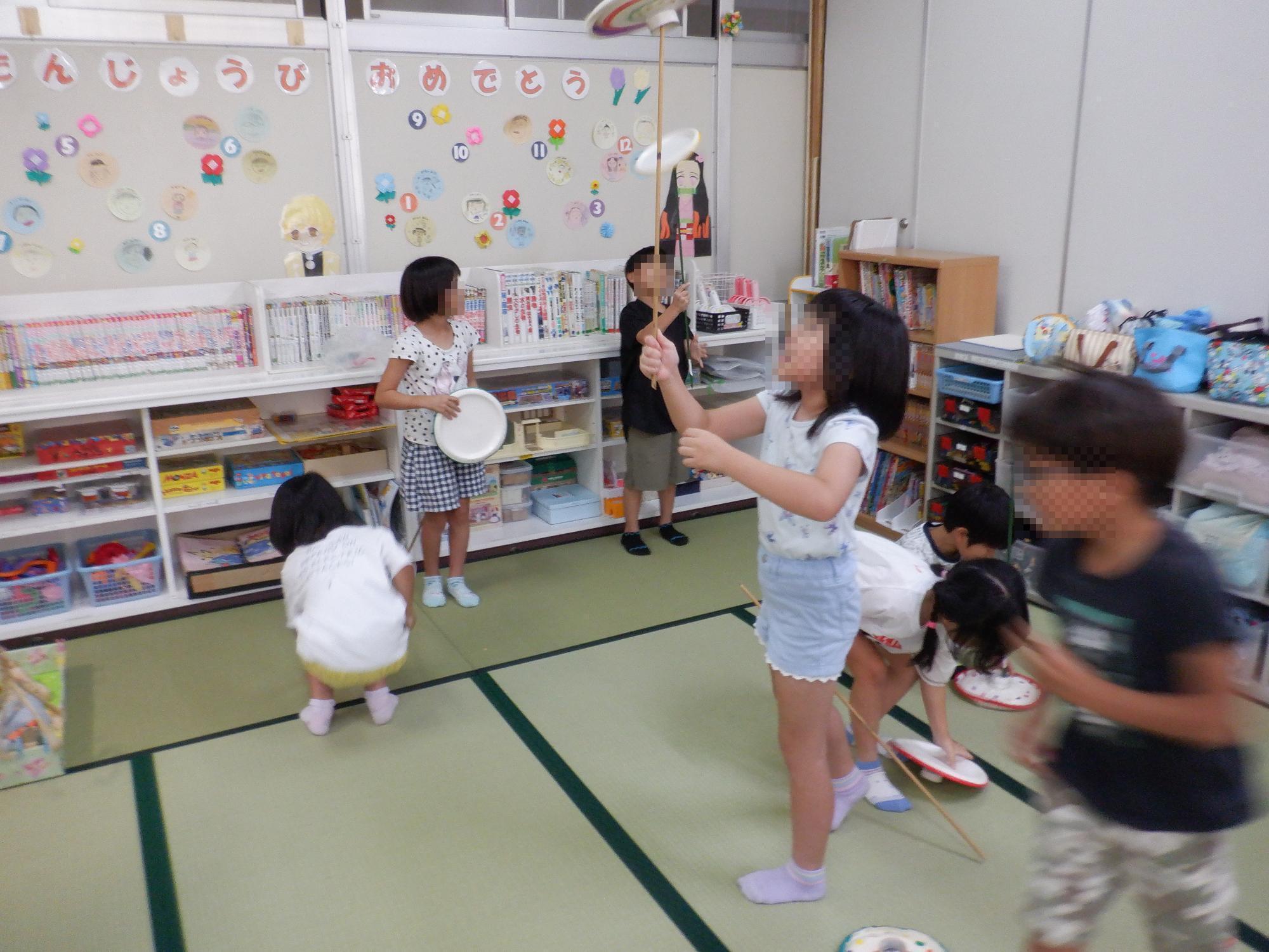 子ども達が皿回しで遊んでいる様子です