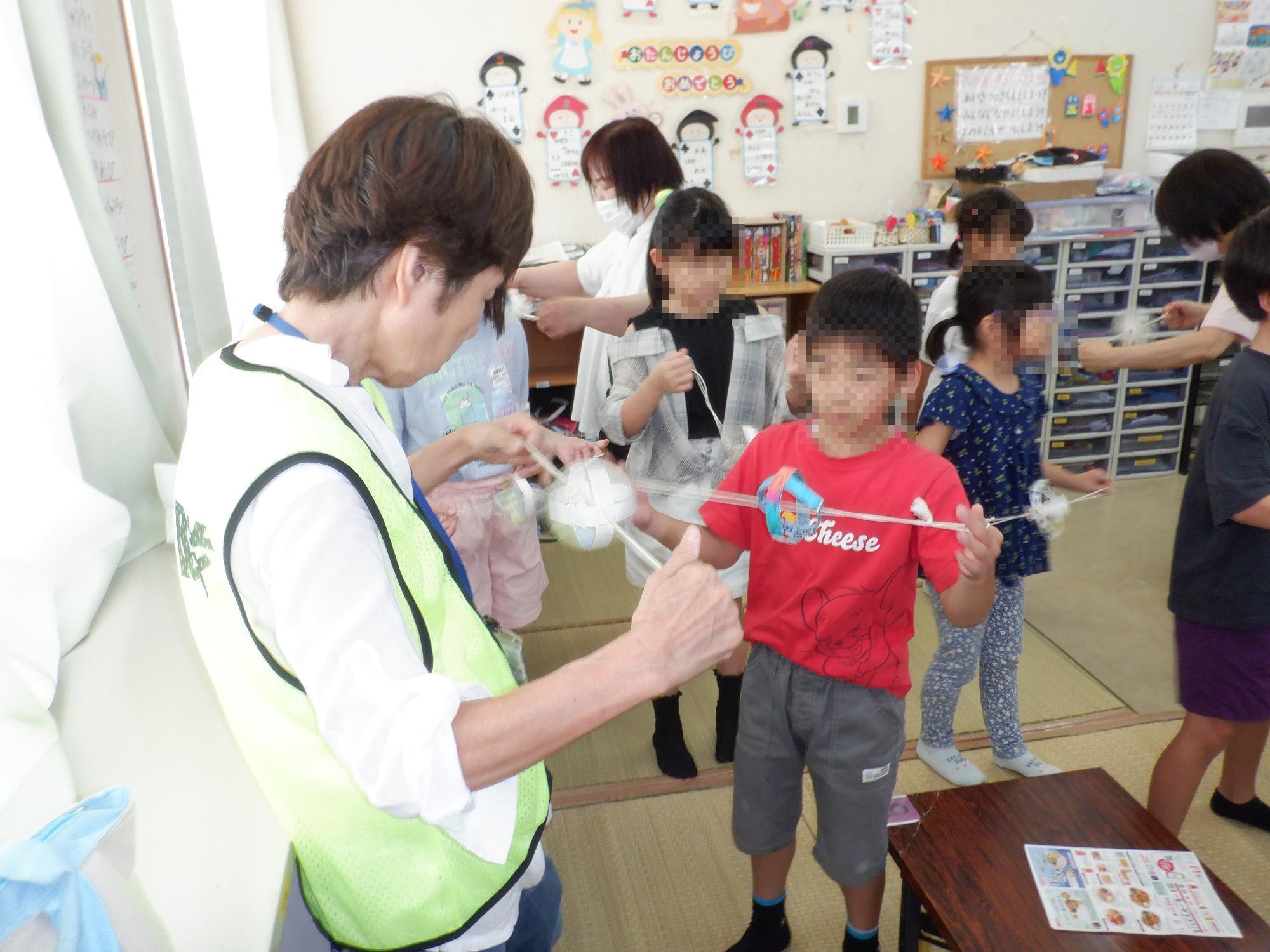 子ども達がブンブンゴマを回している様子です