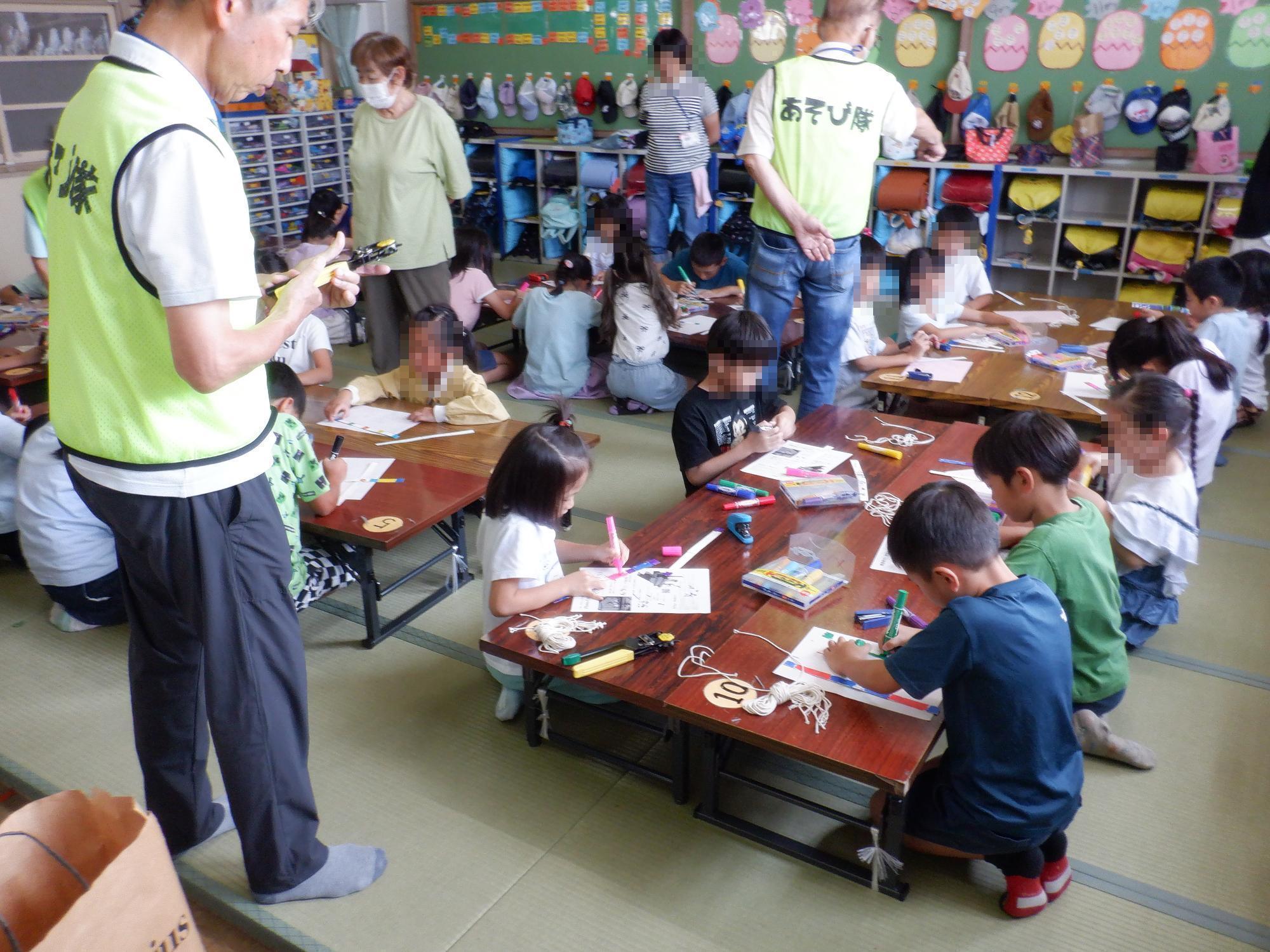 子ども達がブンブンゴマを製作している様子です