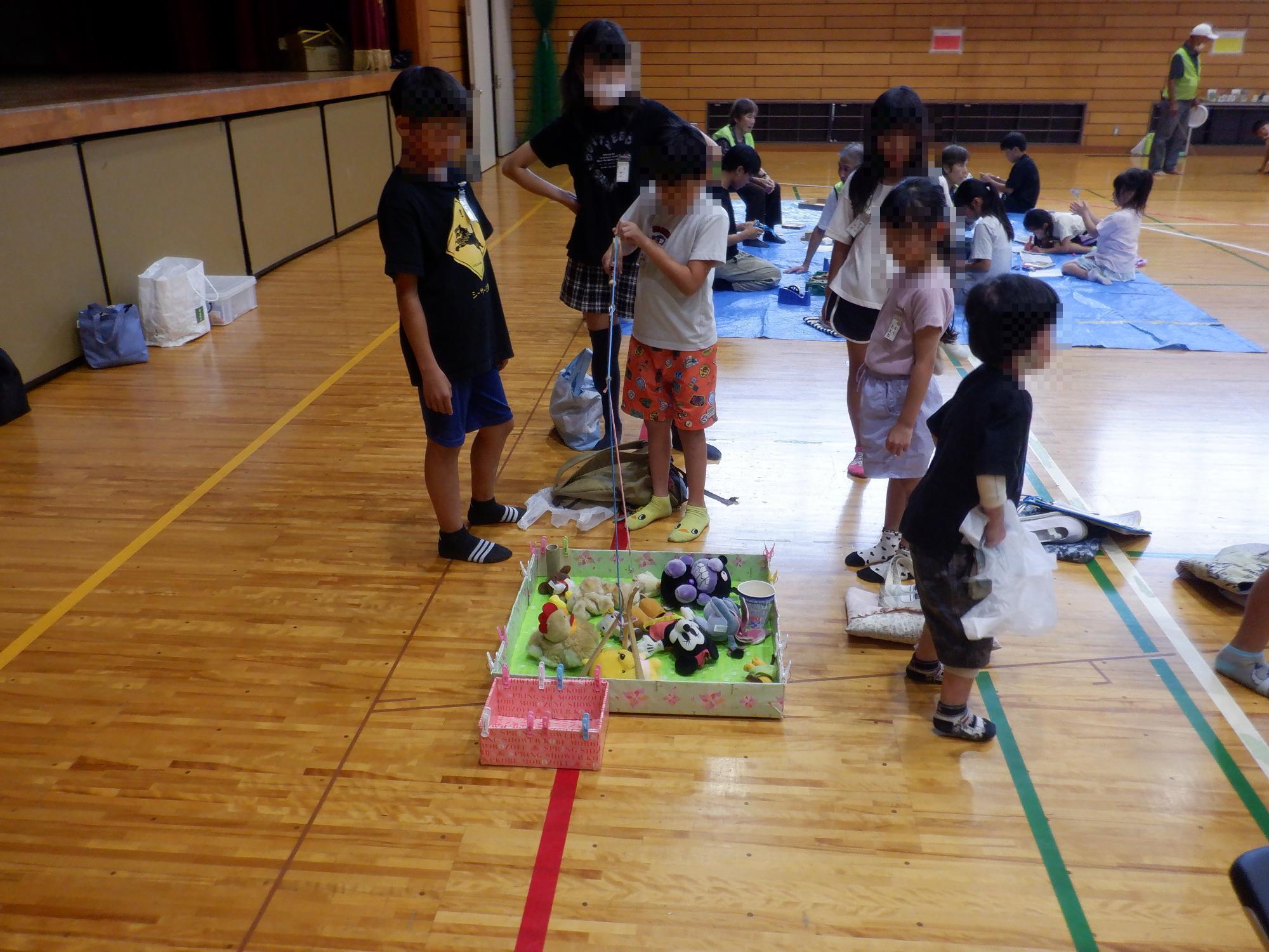 子ども達がユーフォ―キャッチャーで遊んでいる様子です
