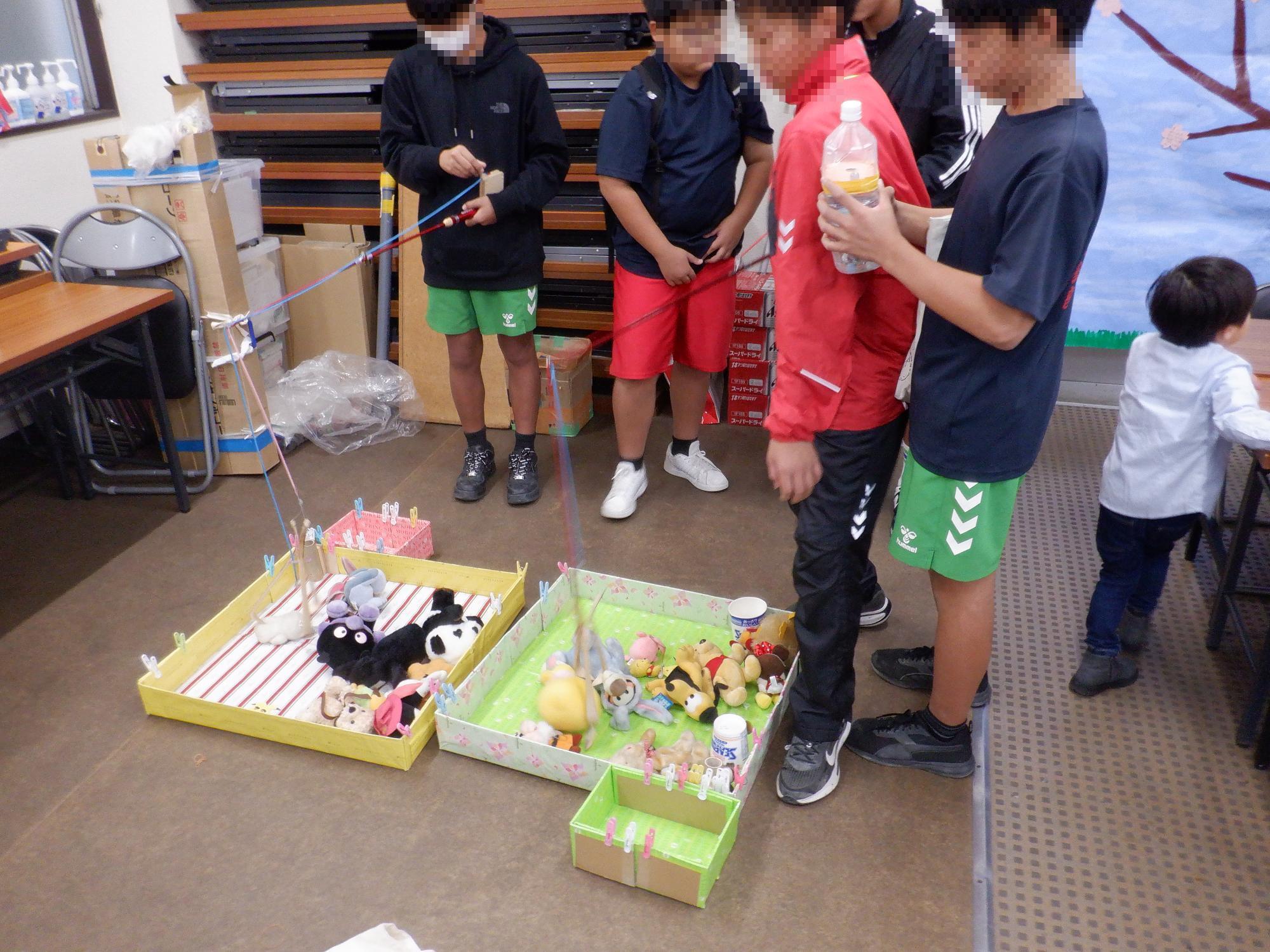 子ども達がユーフォ―キャッチャーで遊んでいる様子です