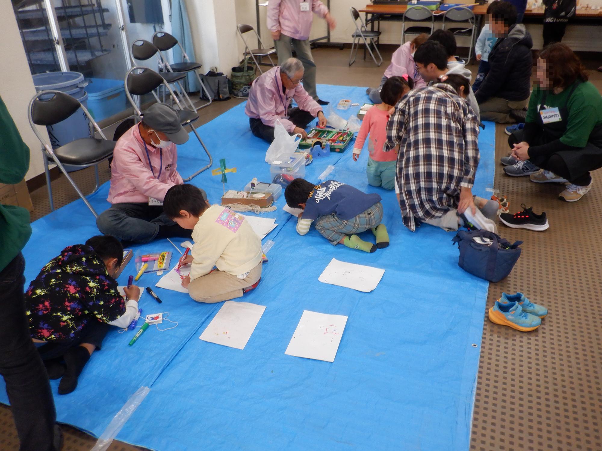 あそび隊が子ども達に手作りおもちゃの作成指導をしている様子です