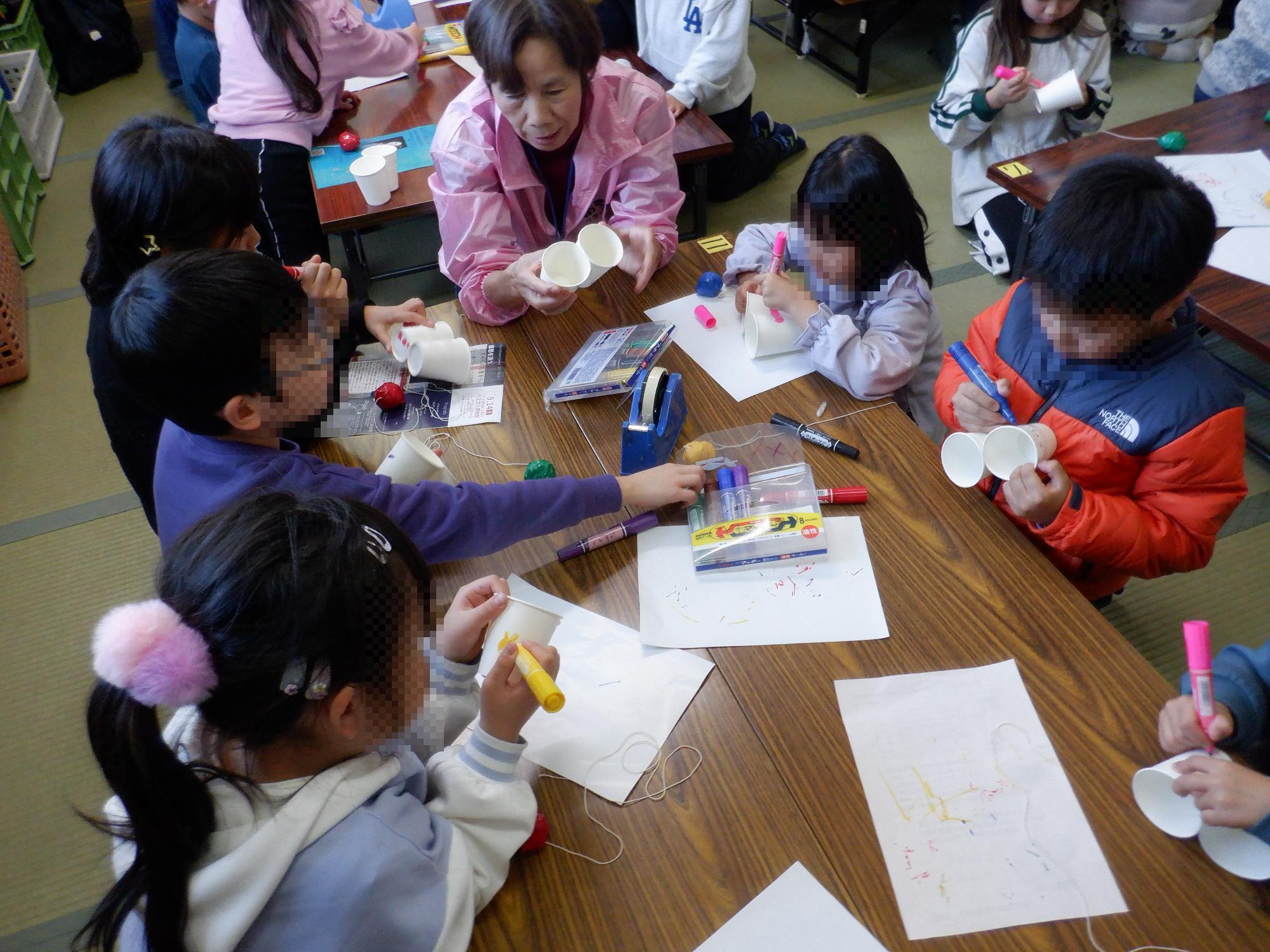 子ども達が紙コップヨーヨーを製作している様子です