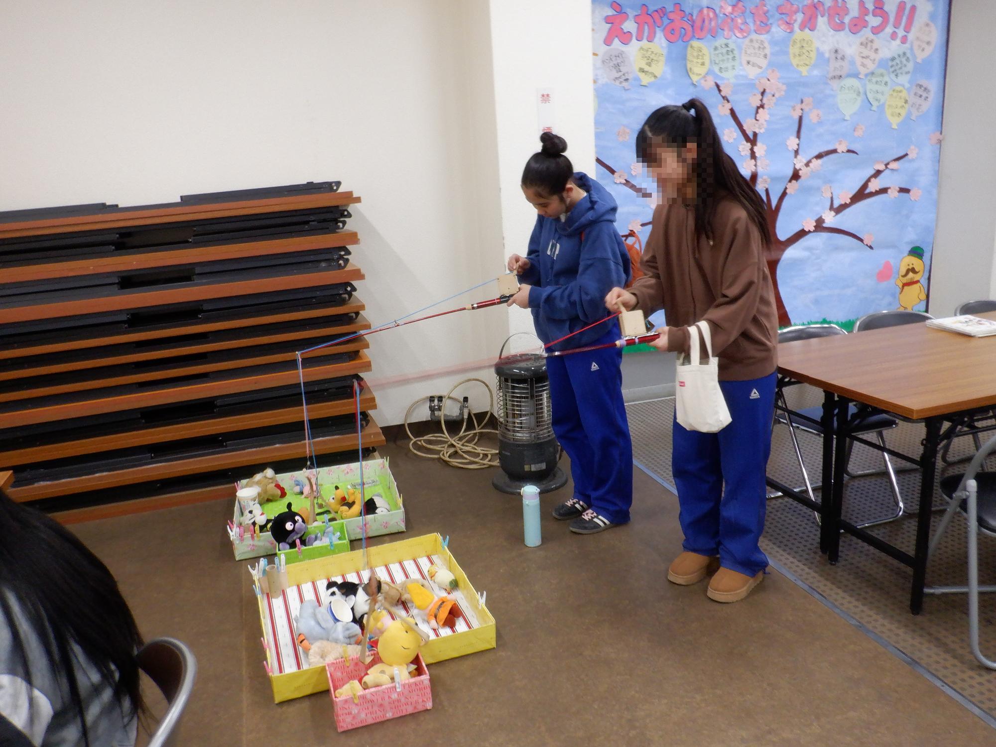 子ども達がユーフォ―キャッチャーで遊んでいる様子です